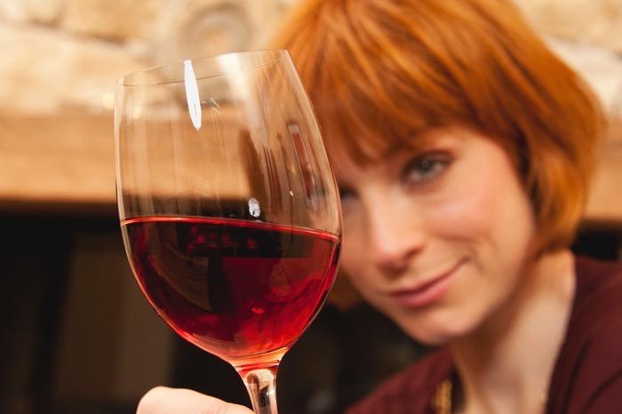 Woman holding a glass of red wine, portrait, close-up