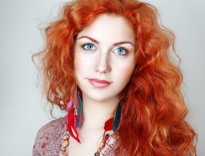 Portrait of a young woman with red hair and blue eyes